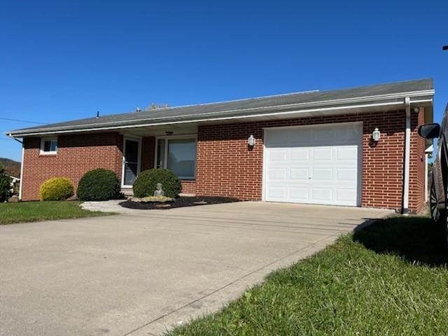 single story home featuring a garage, concrete driveway, and brick siding