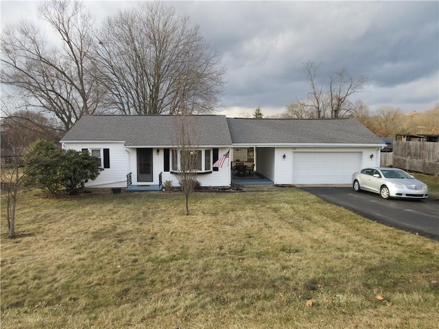 ranch-style home featuring a garage, a shingled roof, aphalt driveway, fence, and a front yard