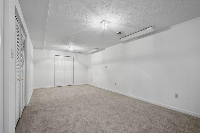 interior space with a textured ceiling, visible vents, and baseboards