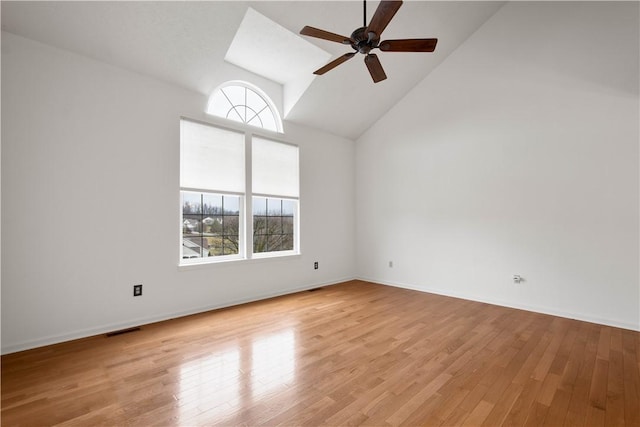 empty room featuring high vaulted ceiling, light wood finished floors, visible vents, and a ceiling fan