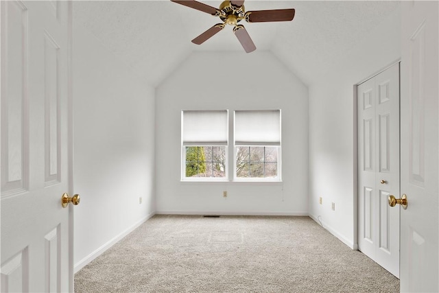 unfurnished bedroom featuring carpet floors, lofted ceiling, baseboards, and a ceiling fan