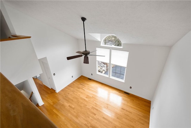 unfurnished living room with light wood-style floors, visible vents, and a textured ceiling