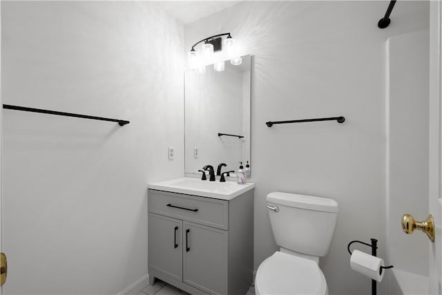 bathroom with vanity, toilet, and baseboards