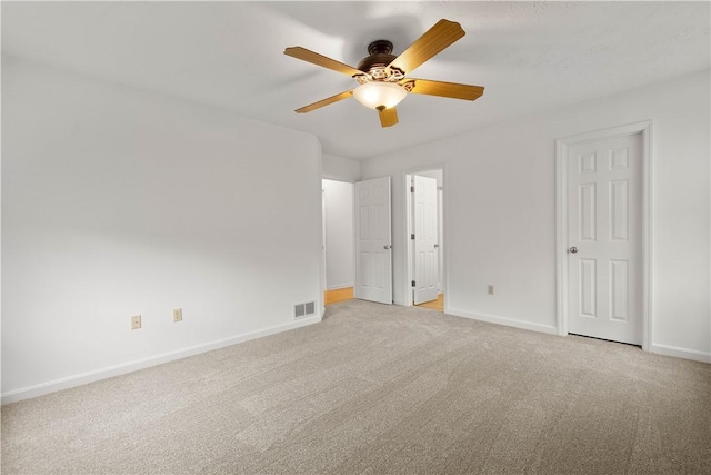 unfurnished bedroom featuring light carpet, ceiling fan, visible vents, and baseboards