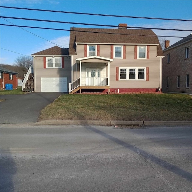 view of front of house featuring a garage, a front yard, covered porch, and aphalt driveway