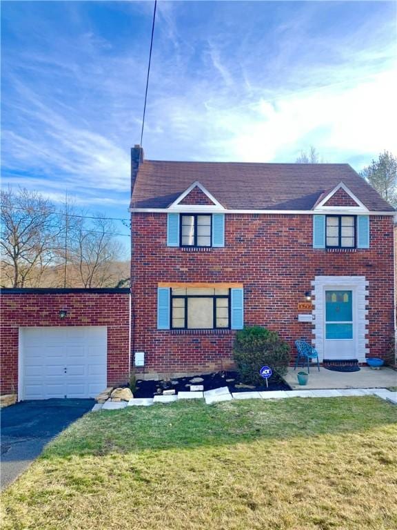 view of front of home with driveway, a front lawn, and brick siding