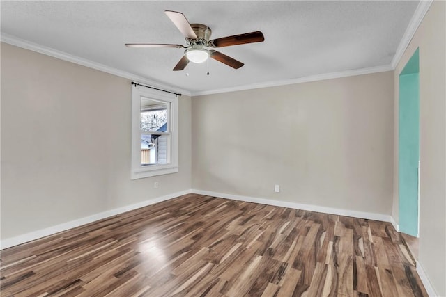 spare room with ornamental molding, a ceiling fan, baseboards, and wood finished floors