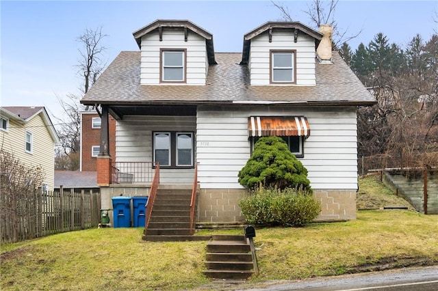 view of front of home with a shingled roof, stairs, fence, and a front lawn