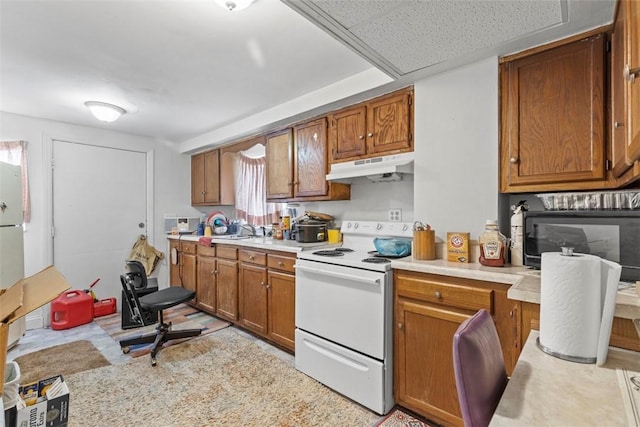 kitchen with under cabinet range hood, white range with electric stovetop, light countertops, and brown cabinetry