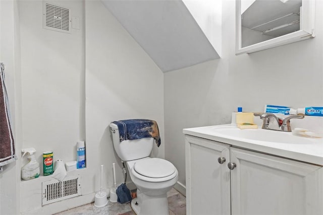 half bathroom featuring toilet, vanity, and visible vents