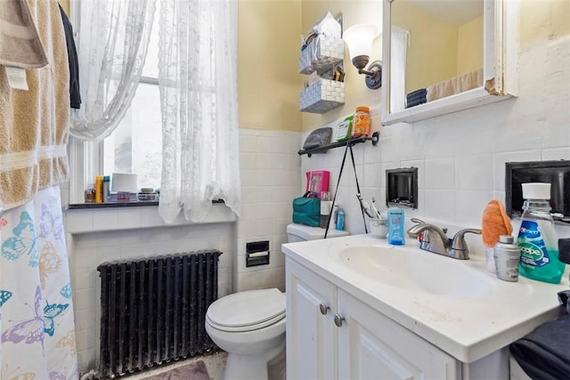 full bath featuring tile walls, radiator, vanity, and toilet