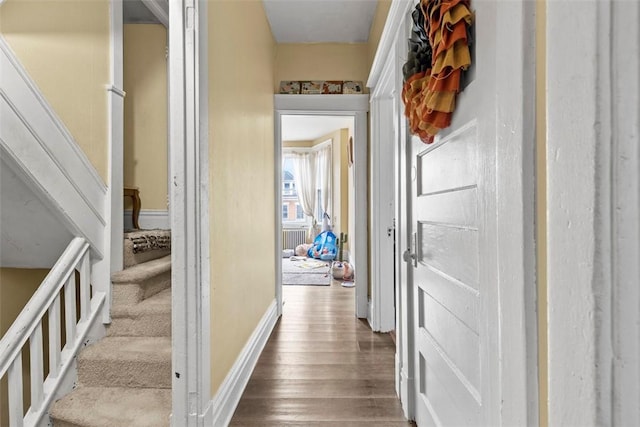 hall with stairway, wood finished floors, and baseboards