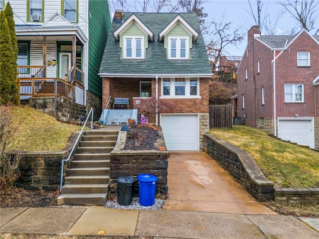 view of front of property featuring a garage, driveway, stairway, and brick siding