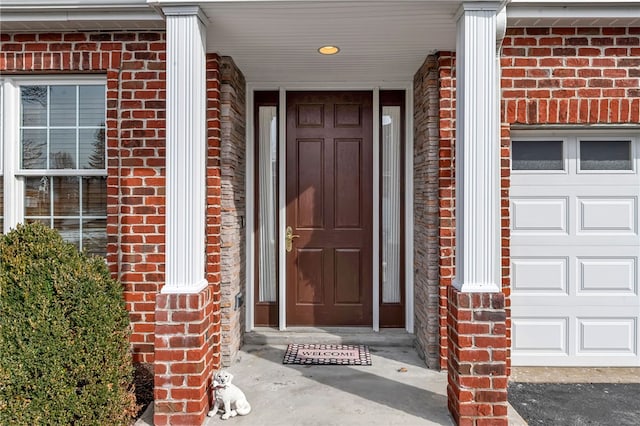 view of exterior entry featuring brick siding