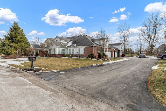 view of front of property with a garage, brick siding, and a front yard