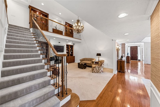 foyer featuring stairs, recessed lighting, wood finished floors, and a notable chandelier