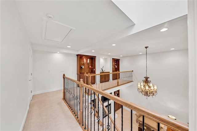 hallway with light carpet, attic access, baseboards, an upstairs landing, and recessed lighting