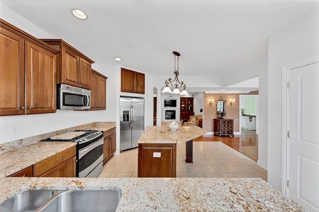 kitchen with pendant lighting, brown cabinets, light tile patterned floors, recessed lighting, and appliances with stainless steel finishes