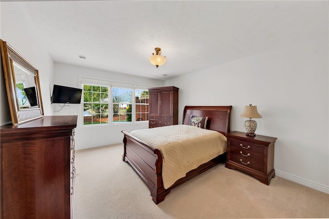 bedroom featuring light colored carpet and baseboards