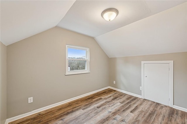 additional living space with lofted ceiling, baseboards, and wood finished floors