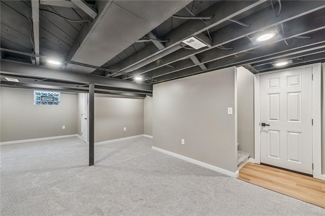 below grade area with carpet, visible vents, and baseboards