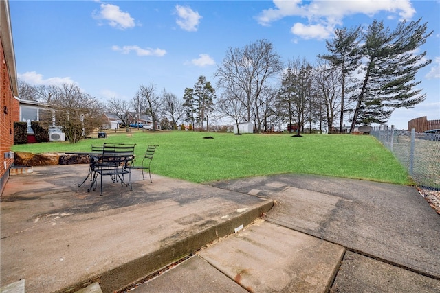 view of yard with an outbuilding, a patio, a storage shed, and fence