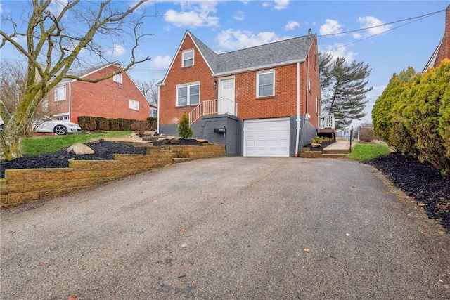 view of front of house with driveway, brick siding, and an attached garage