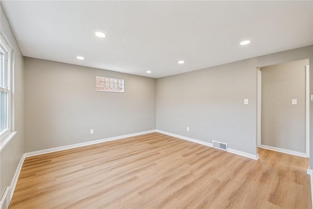 empty room featuring light wood-type flooring, visible vents, and recessed lighting