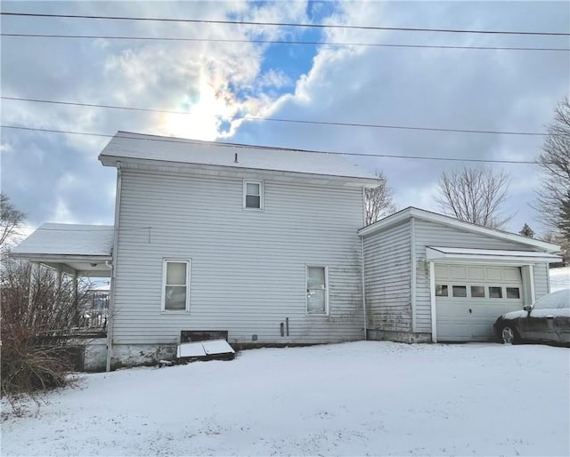 snow covered property featuring a garage