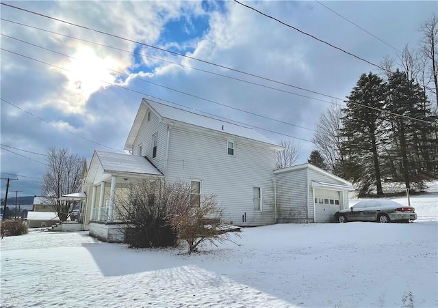 view of snowy exterior with a garage