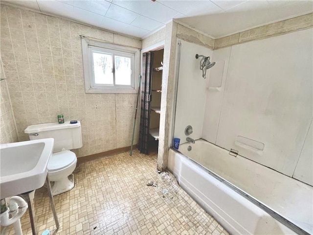 bathroom with  shower combination, toilet, and tile walls