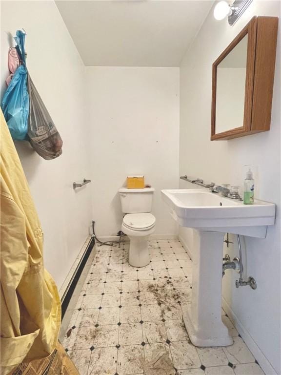 half bath featuring toilet, baseboards, and tile patterned floors