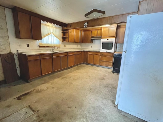 kitchen with under cabinet range hood, white appliances, light countertops, open shelves, and brown cabinetry