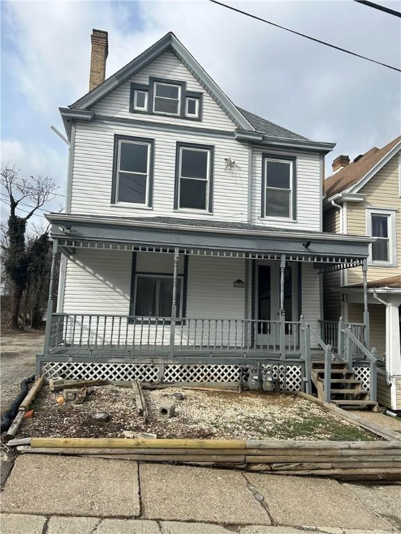 view of front of house featuring covered porch and a chimney