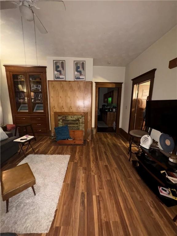 living area with dark wood-style floors and a ceiling fan