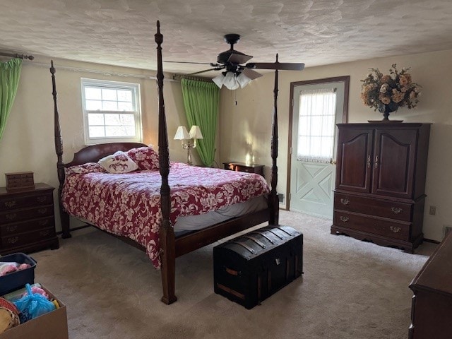 bedroom with light carpet, ceiling fan, and a textured ceiling