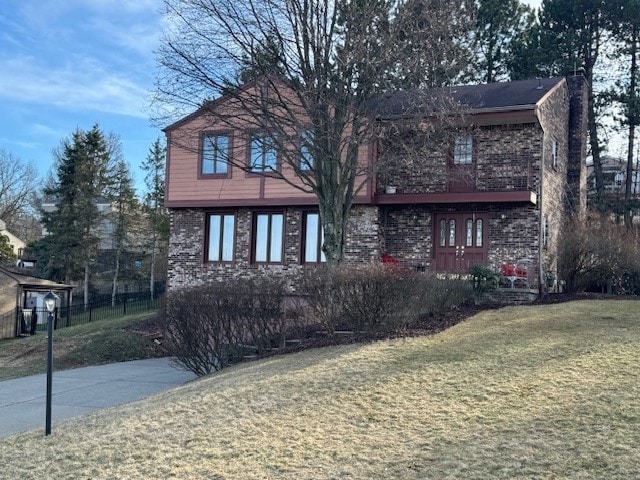 view of front of home featuring brick siding and a front lawn