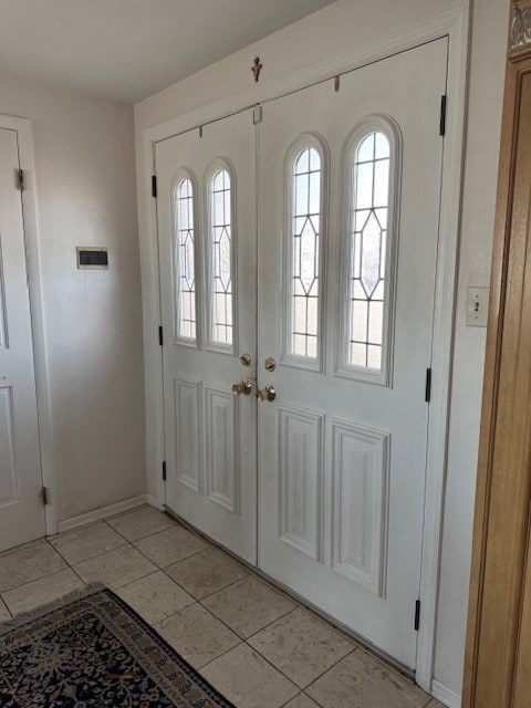 foyer with baseboards and french doors