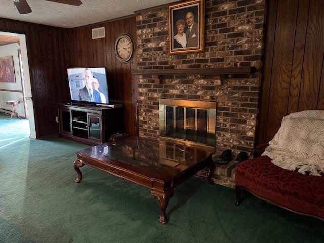 living room with a textured ceiling, wooden walls, a fireplace, visible vents, and carpet