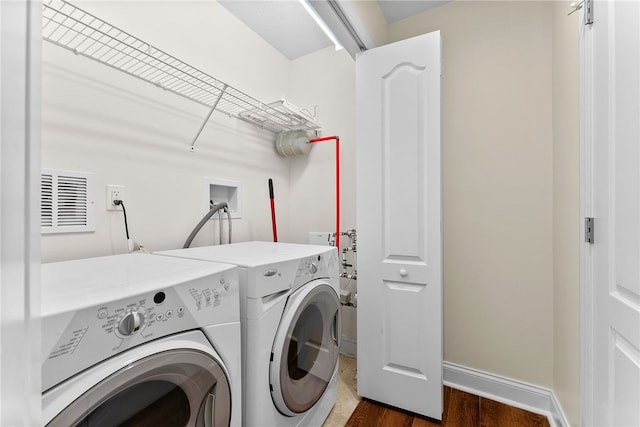 laundry room with laundry area, washing machine and dryer, baseboards, and dark wood-style flooring