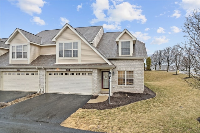 view of front of home with brick siding, an attached garage, and aphalt driveway