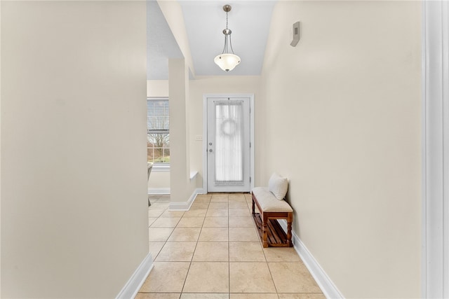 doorway to outside with light tile patterned floors and baseboards