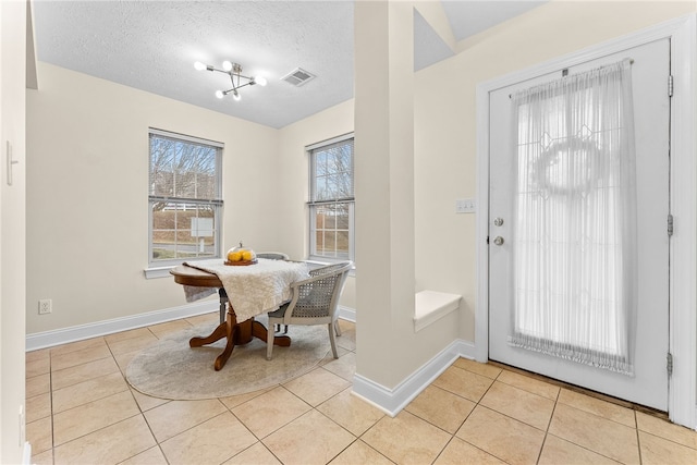 dining room with visible vents, a textured ceiling, baseboards, and light tile patterned flooring