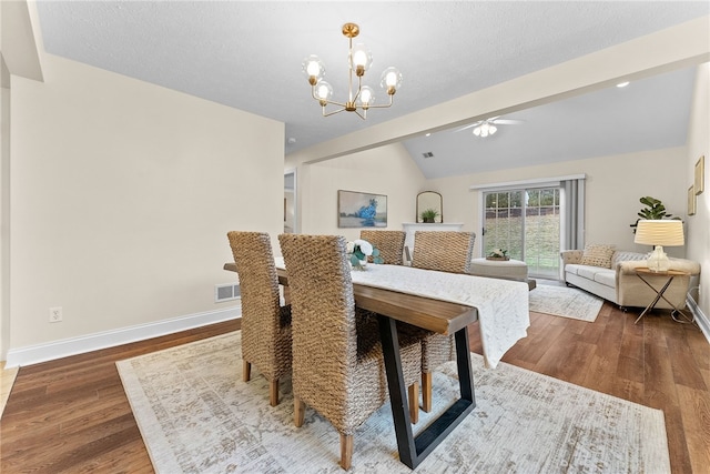 dining space featuring lofted ceiling, wood finished floors, baseboards, and an inviting chandelier