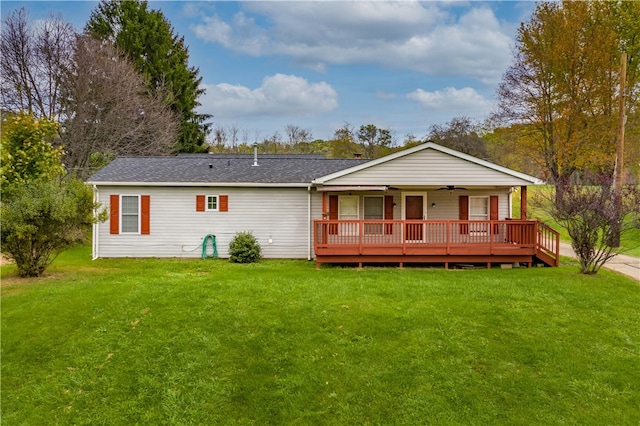 back of property with ceiling fan and a lawn