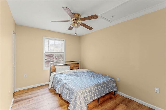 bedroom featuring ceiling fan, baseboards, and wood finished floors