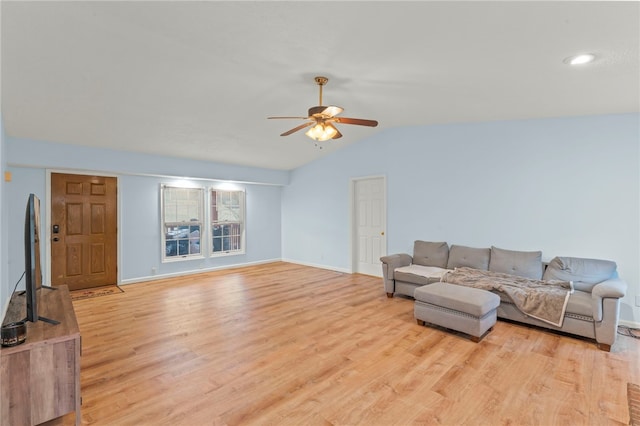 living room featuring light wood-style floors, lofted ceiling, baseboards, and a ceiling fan