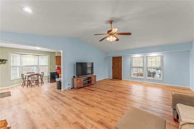 living room with light wood finished floors, ceiling fan, baseboards, and vaulted ceiling