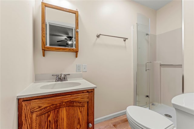 full bath featuring toilet, a stall shower, baseboards, and vanity