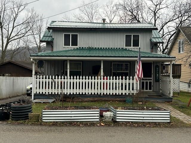 view of front of property with covered porch, metal roof, and board and batten siding